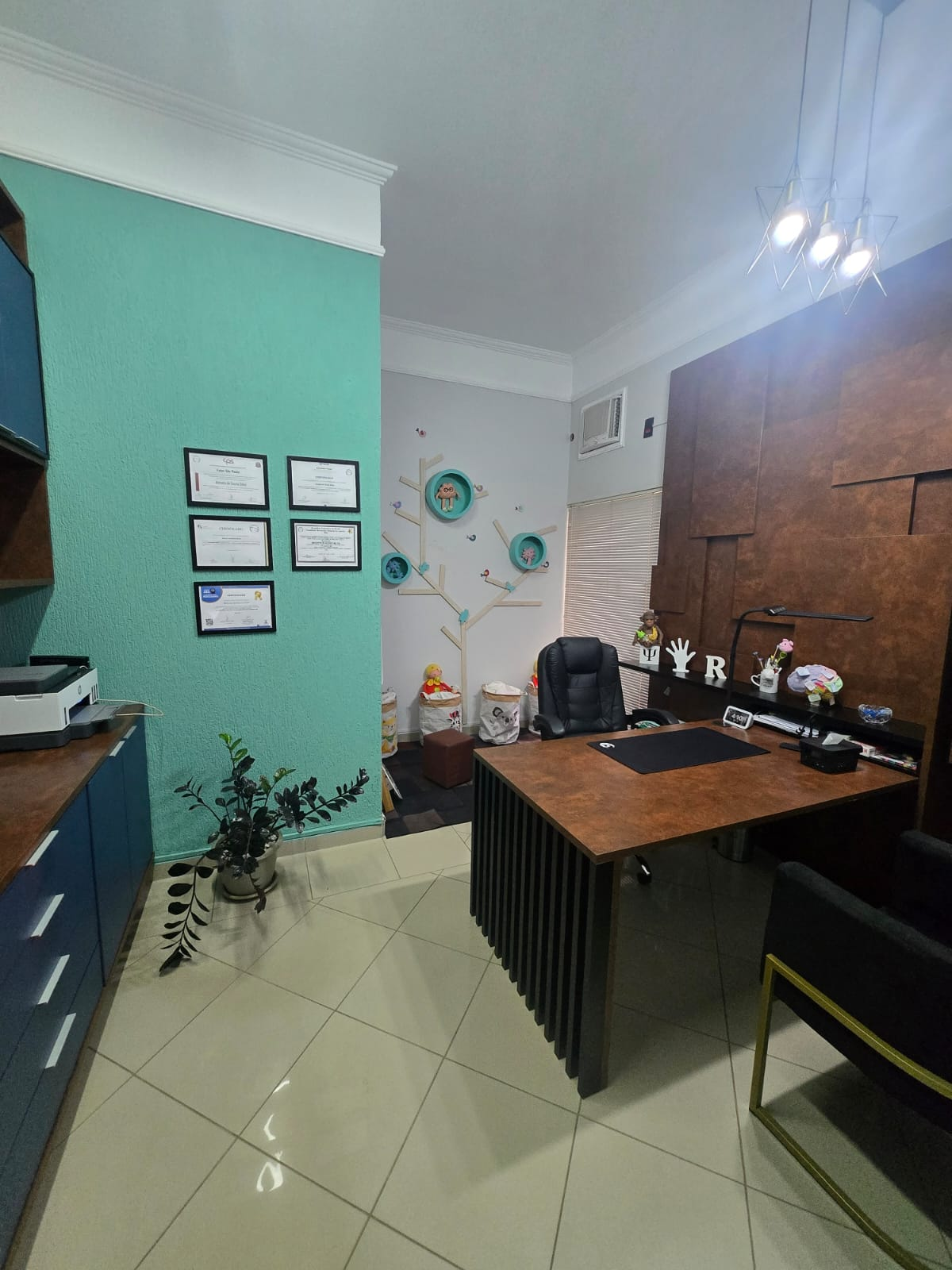 Consultório Neuroninho com mesa de atendimento e área infantil